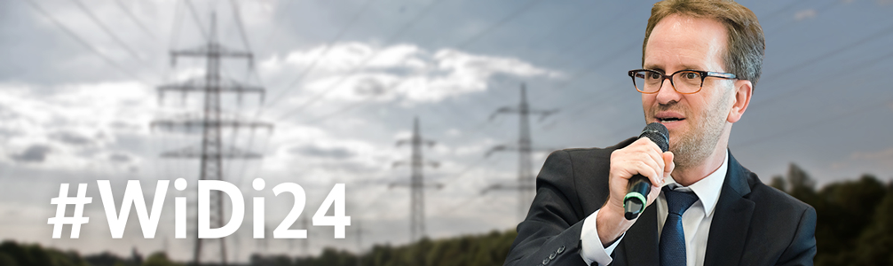 Klaus Müller, Präsident der Bundesnetzagentur, und der Hashtag #WiDi24, im Hintergrund unscharfe Strommasten. Klaus Müller, Präsident der Bundesnetzagentur, und der Hashtag #WiDi24, im Hintergrund unscharfe Strommasten.